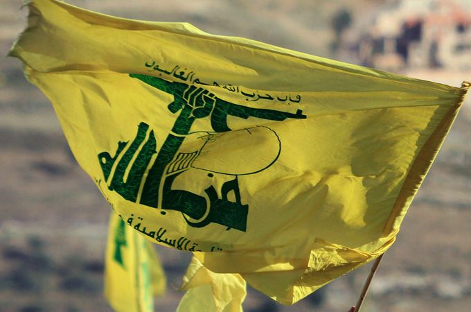 Supporters wave Hezbollah flags as they listen to Hassan Nasrallah’s televised speech. In Bint Jbeil, on 25 May 2012, the 12th anniversary of liberation from Israel