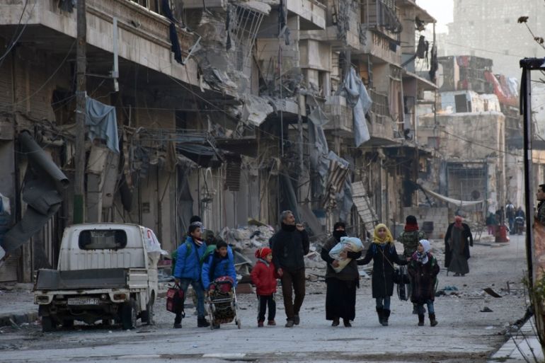People, who evacuated the eastern districts of Aleppo, carry their belongings as they arrive in a government held area of Aleppo