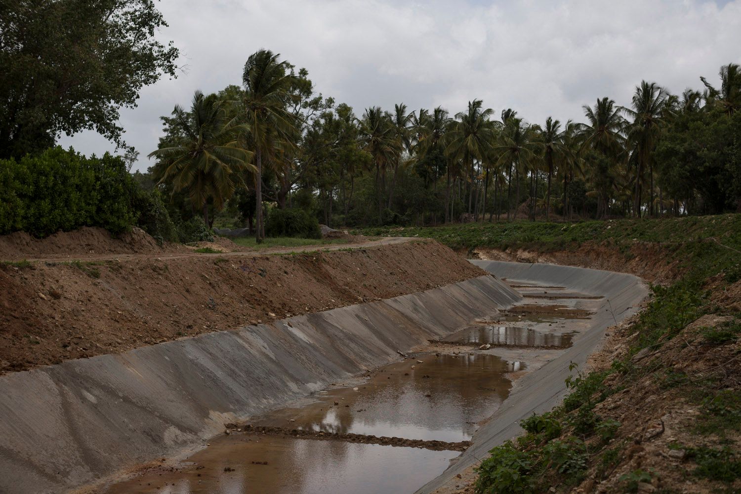 An irrigation channel from the Krishna Raja Sagara dam runs dry on a hot day in the middle of the rainy season in July 2016. Mandya district is supposed to be irrigated by the dam but as the monsoon becomes unreliable and the rains diminish every year, there simply isn't enough water for all the farmed areas [Janos Chiala/Al Jazeera]