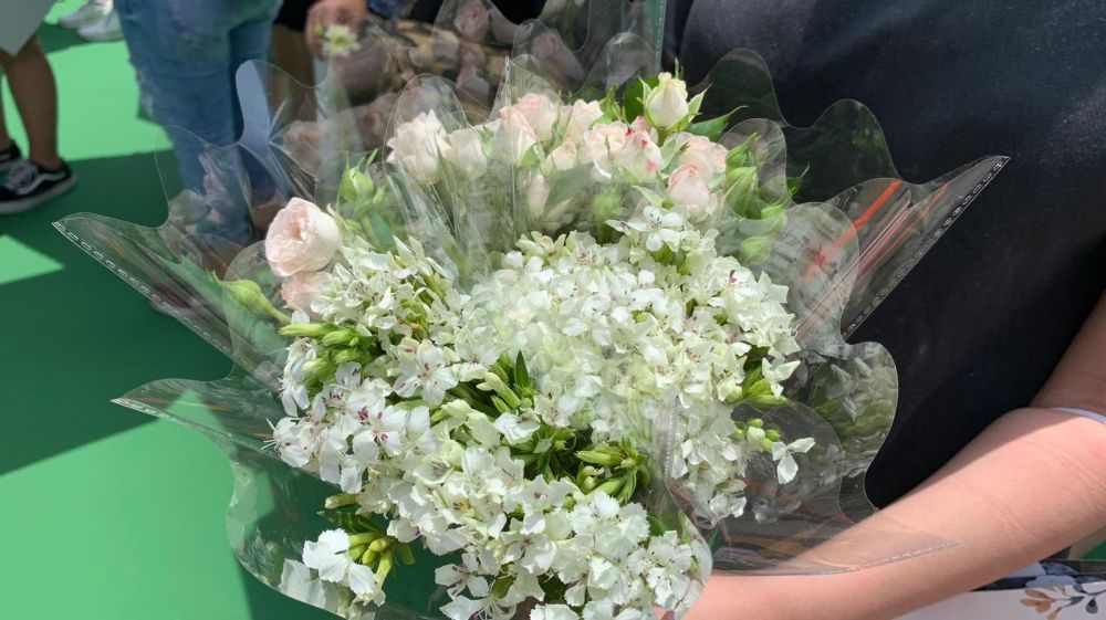 A demonstrator holds a bunch of flowers in tribute to a man who died protesting against the bill on Saturday