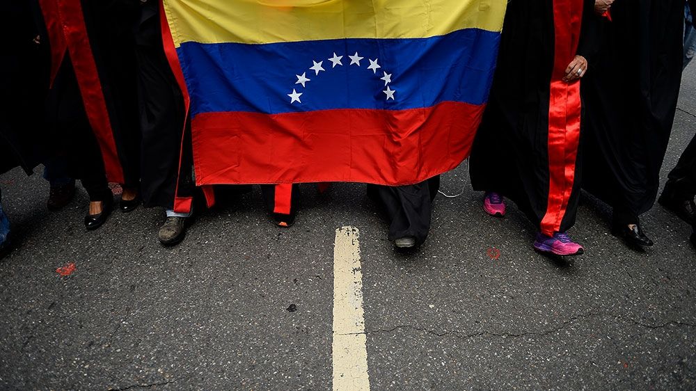 A group of lawyers dressed in judicial robes and carrying a Venezuelan national flag protest outside Venezuela’s Supreme Court of Justice building against the absence of the rule of law in Venezuela at Chacao neighbourhood, in Caracas