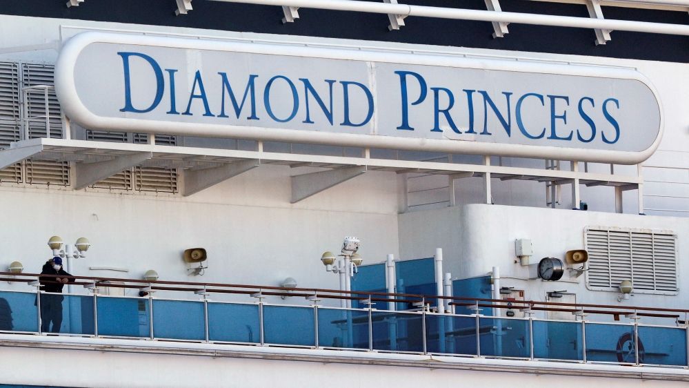 A passenger wearing a mask stands on the deck of the cruise ship Diamond Princess, as the vessel’s passengers continue to be tested for coronavirus, at Daikoku Pier Cruise Terminal in Yokohama, south of Tokyo, Japan on February 13, 2020.