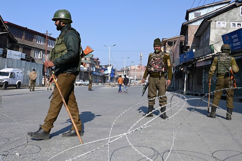 Indian paramilitary trooper stands guard at a checkpoint during a one-day strike called by Jammu and Kashmir Libration Front (JKLF) to demand the return of the remains of Afzal Guru, who was executed