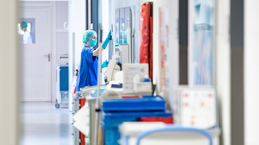 A medical staffer wearing a protective mask and clothing cleans at the intensive care unit at the St. Josef Hospital in Bochum, Germany