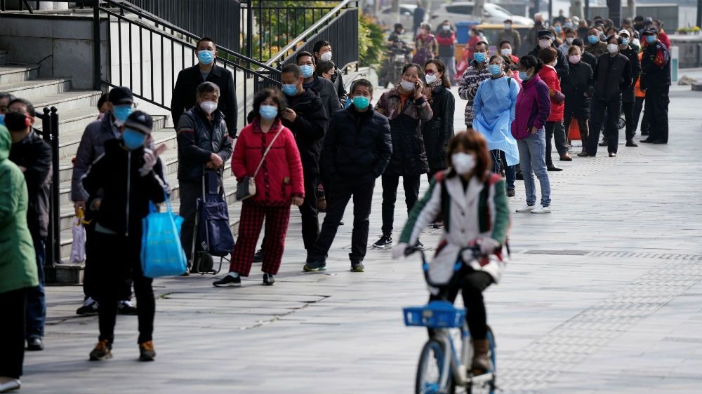 People queue to enter a supermarket in Wuhan as life slowly returns to normal