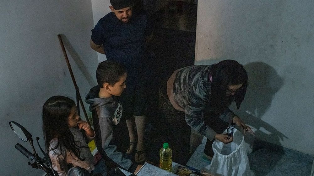 Grecia Vargas opens a bag of food aid that a network of business owners distributed to informal workers affected by the COVID-19 crisis