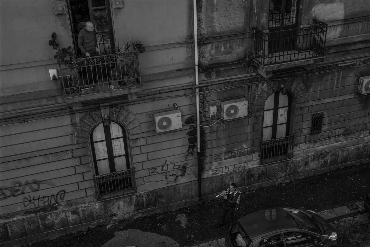 Michele, a trumpeter, plays in the city streets alleviating the quarantine of people with his music. The streets are empty but the people often stand in the balcony to take some air or to sing togethe