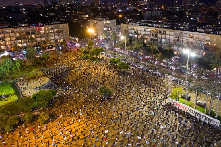 People keep social distance amid concerns over the country''s coronavirus outbreak, during "Black Flag" protest against Prime Minister Benjamin Netanyahu and government corruption, at Rabin square