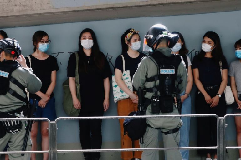 Riot police stop and search people during a march at the anniversary of Hong Kong''s handover to China from Britain in Hong Kong