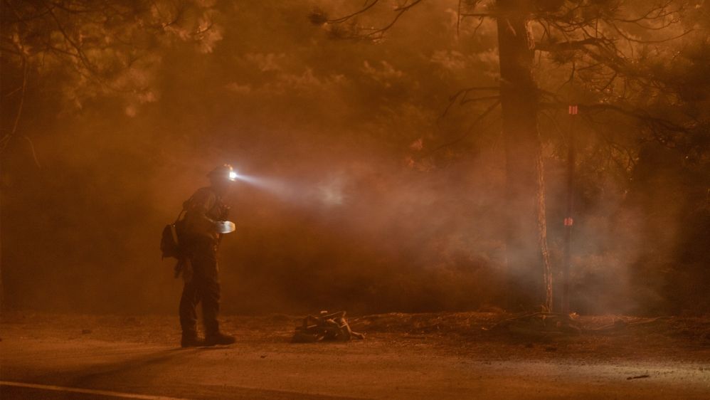 A firefighter keeps watch on flames that could jump the Angeles Crest Highway at the Bobcat Fire in the Angeles National Forest on September 11, 2020 north of Monrovia, California