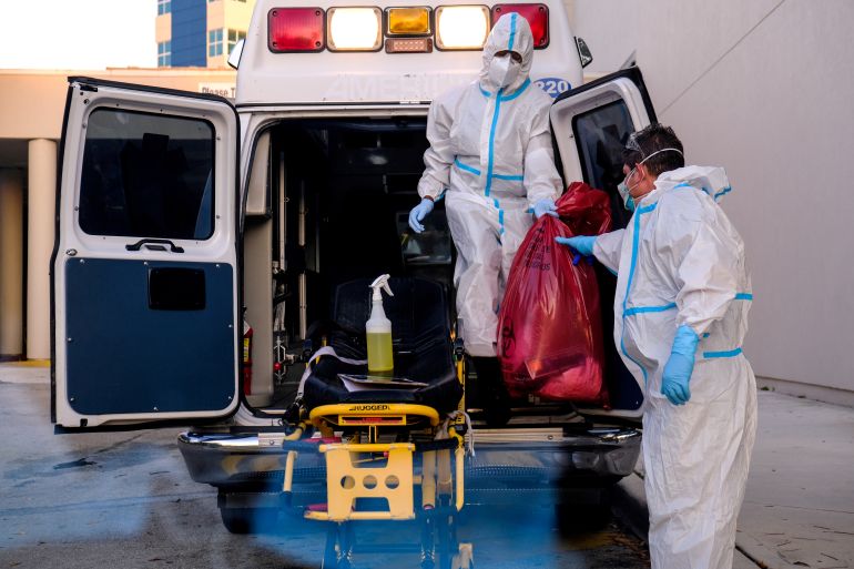 Healthcare workers clean their materials outside Memorial West Hospital where coronavirus patients are treated, in Pembroke Pines, Florida