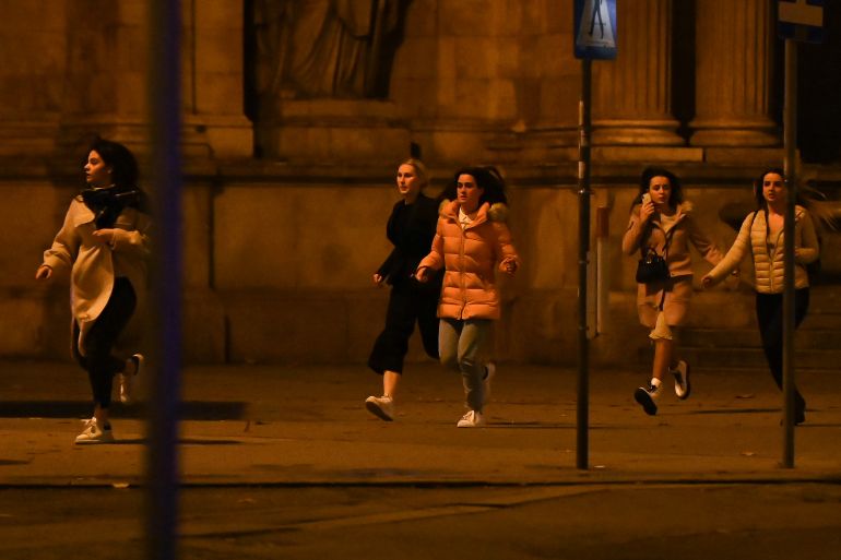 Women run away from the first district near the state opera, central Vienna on November 2, 2020, following a shooting near a synagogue