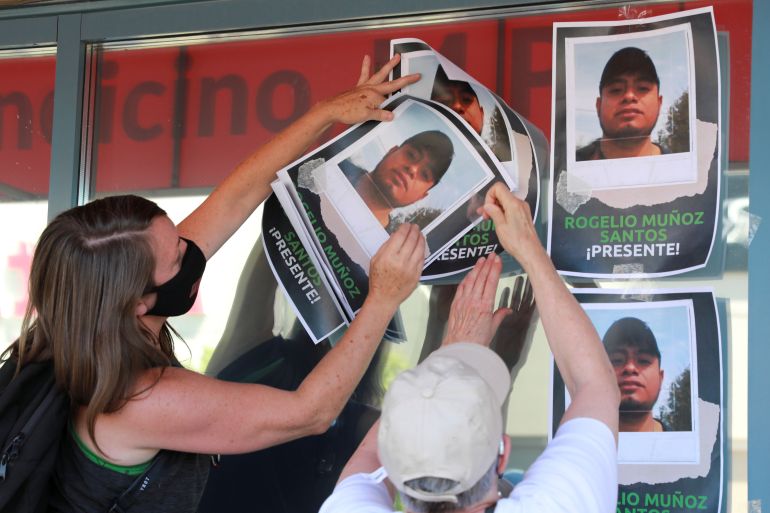 Supporters tape photographs of migrant worker Rogelio Munoz Santos, who died from COVID-19, during a pro-immigration rally in Toronto, Ontario on July 4