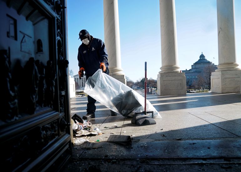 A worker cleans up debris outside the US Capitol a day after supporters of US President Donald Trump stormed the Capitol in Washington, DC