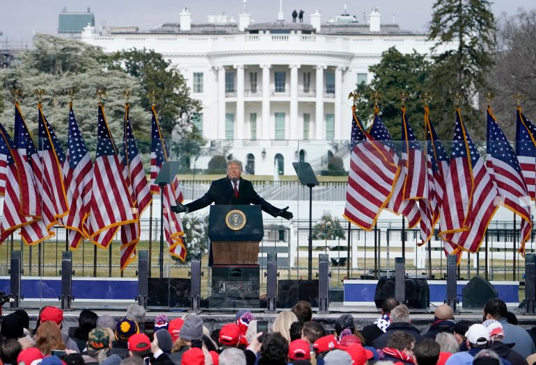 With the White House in the background, President Donald Trump speaks at a rally Wednesday