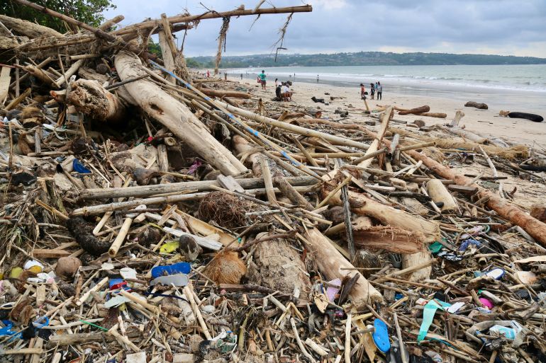 The rubbish includes old plastic containers and discarded bags as well as logs and branches. People in Bali say the pollution comes from neighbouring Java [Al Jazeera Staff]