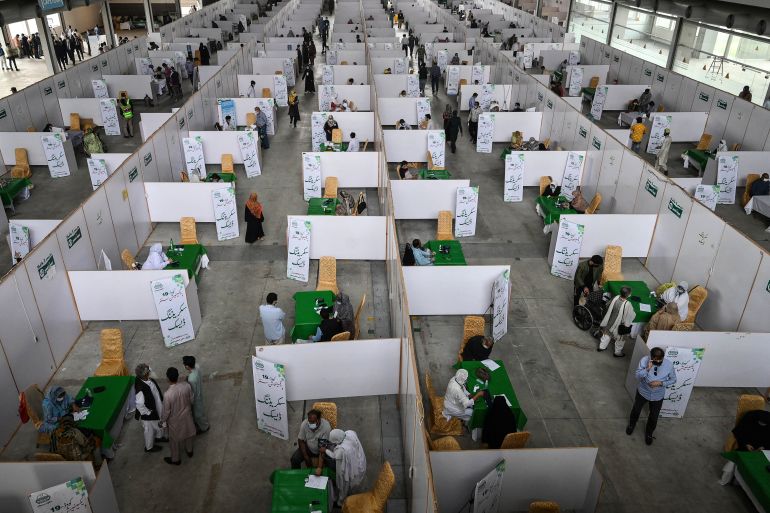 Senior citizens receive Chinese-made Sinopharm vaccine doses at a vaccination centre inside an exposition centre in Lahore
