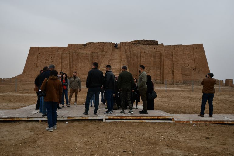 Tourists stand in front of the Ziggurat temple in the ancient city of Ur