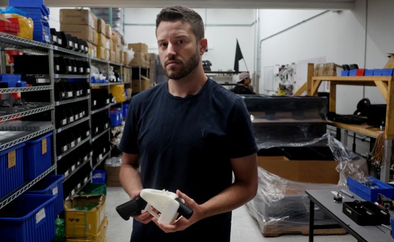 Cody Wilson poses with an example of a 3D-printed gun, called the ‘Liberator’, which his company Defense Distributed designs at his factory in Austin, Texas on August 1, 2018