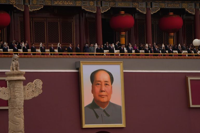 Chinese President Xi Jinping (centre) on the balcony above a large portrait of Mao Zedong