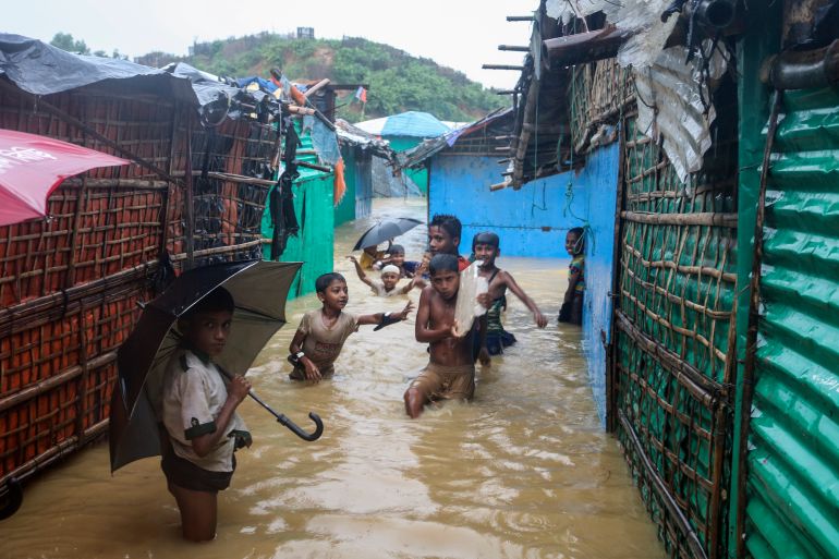 Rohingya refugee children play in floodwaters at the Rohingya refugee camp in Kutupalong, Bangladesh