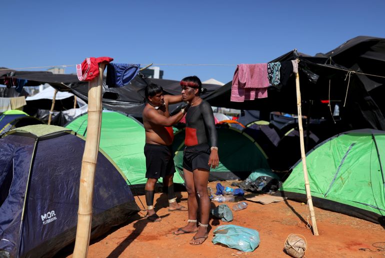 Xavante Indigenous people paint their bodies at Camp Luta pela Vida