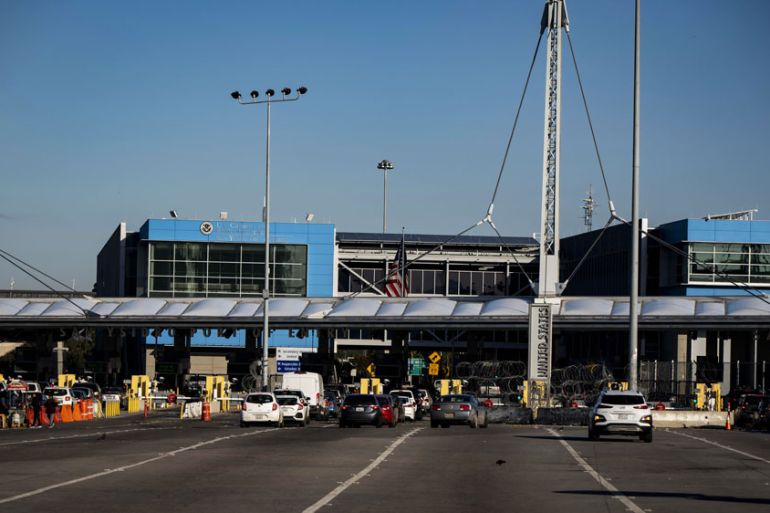 Travellers wait to cross into the United States at the San Ysidro Port of Entry border crossing in Tijuana, Baja California, Mexico, 21 March 2020.