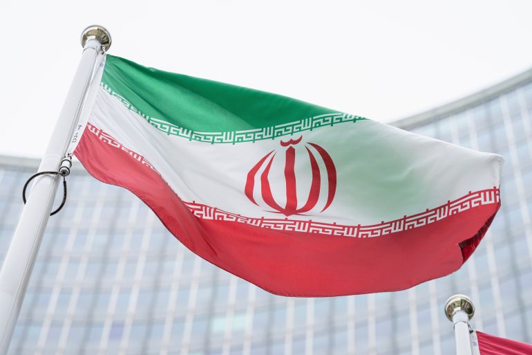 The flag of Iran waves in front of the the International Center building with the headquarters of the International Atomic Energy Agency