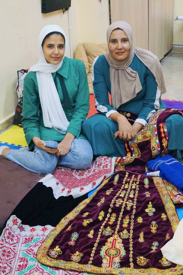 Razan, (left), and her mother pose for a photo with their handmade dresses
