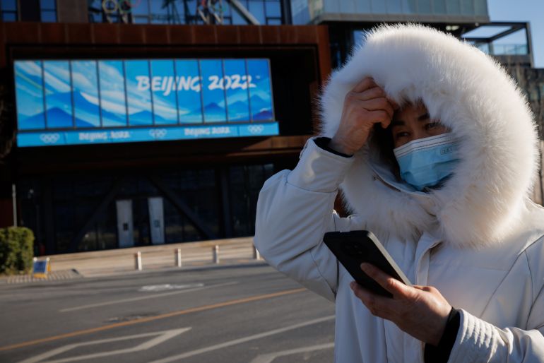 A woman stands outside the headquarters of the organising committee for the Winter Games