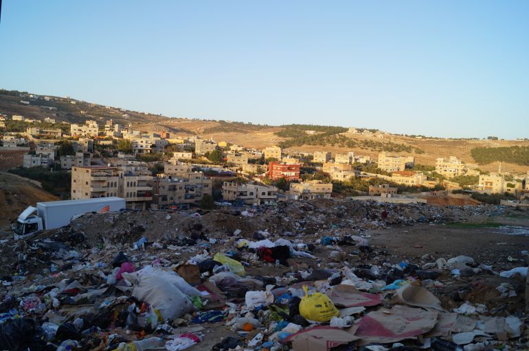 Rubbish piles up on the outskirts of Gaza Camp. Pictured beyond the garbage are spacious apartment buildings and rolling hills – a scene opposite from what lies inside the camp’s perimeters