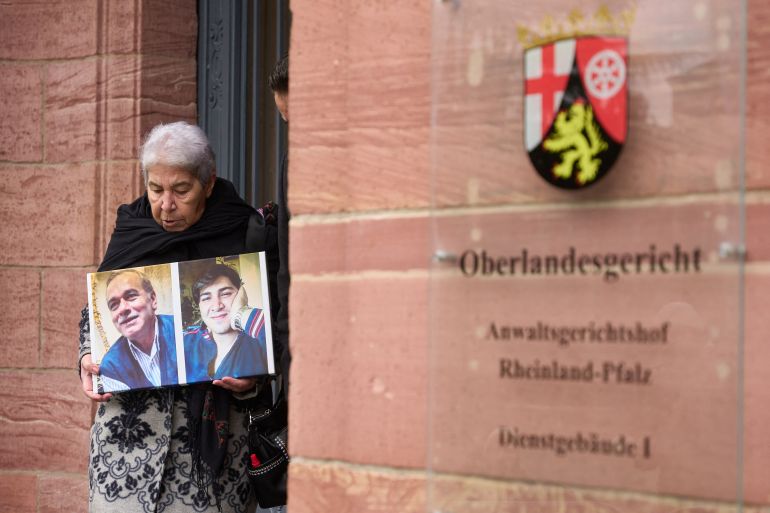 Syrian Fadwa Mahmoud holds a photo of her son and partner as she leaves the court in Koblenz, western Germany, on January 13, 2022