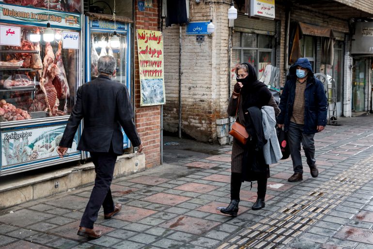 People walk past a butcher's shop in the south of Iran's capital Tehran.