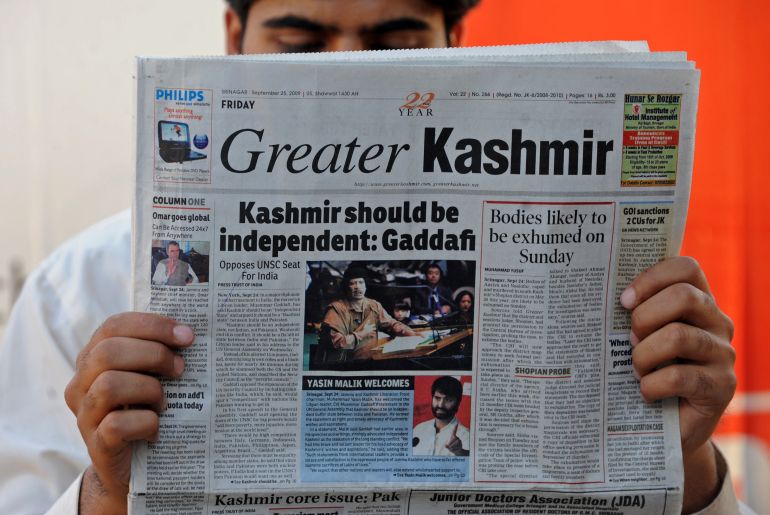 A Kashmiri man reads a newspaper featuring an image of Libyan leader Moamer Kadhafi addressing The United Nations General Assembly outside a stall in Srinagar on September 25, 2009