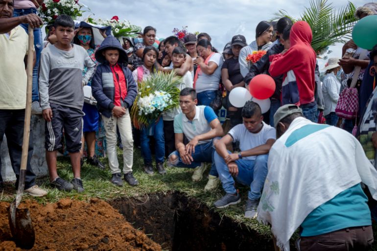 Breiner’s relatives look down at where his coffin lies during the teenager’s burial on January 17, 2022 in Las Delicias