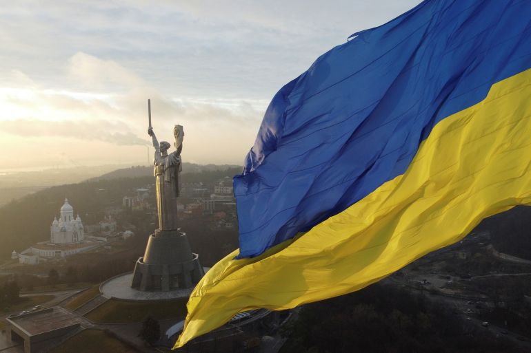 Ukraine’s biggest national flag on the country’s highest flagpole and the giant Motherland monument are seen at a compound of the World War II museum in Kyiv, Ukraine, December 16, 2021