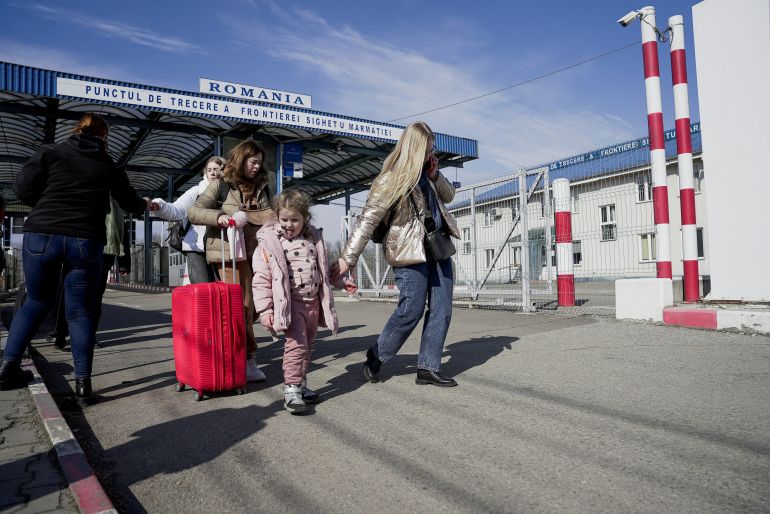 A woman holds her child’s hand as they arrive from Ukraine to Romania, at Sighetu Marmatiei border crossing near Baia Mare, Romania
