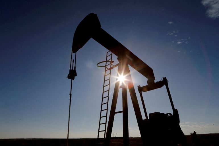 FILE PHOTO: The sun is seen behind a crude oil pump jack in the Permian Basin in Loving County, Texas, U.S., November 22, 2019.
