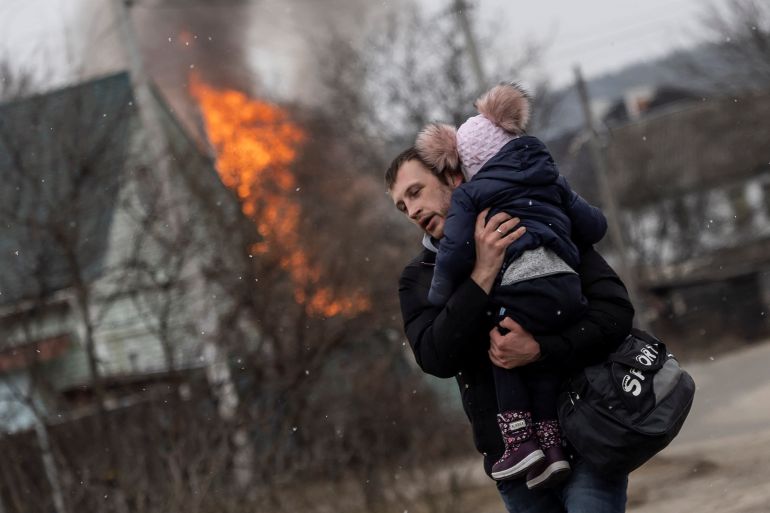 A man and a child escape from the town of Irpin