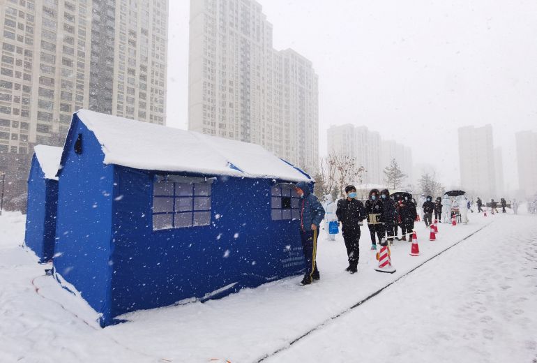 Residents queue in the snow to be tested for COVID-19 at a makeshift testing site in Changchun in China’s Jilin province [cnsphoto via Reuters]