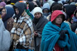 Refugees, mostly women and children, wait in a crowd for transport after fleeing from Ukraine and arriving at the border crossing in Medyka, Poland