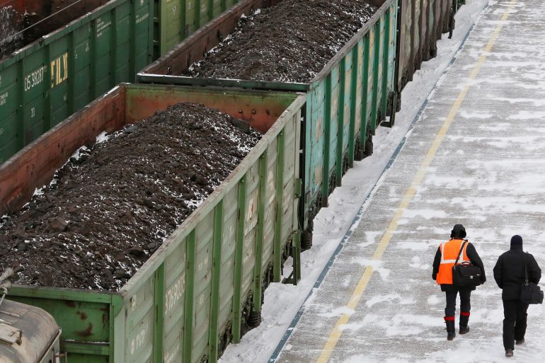 Men are seen walking along wagons oaded with coal at the Zlobino railway station in Russia's Siberian city of Krasnoyarsk
