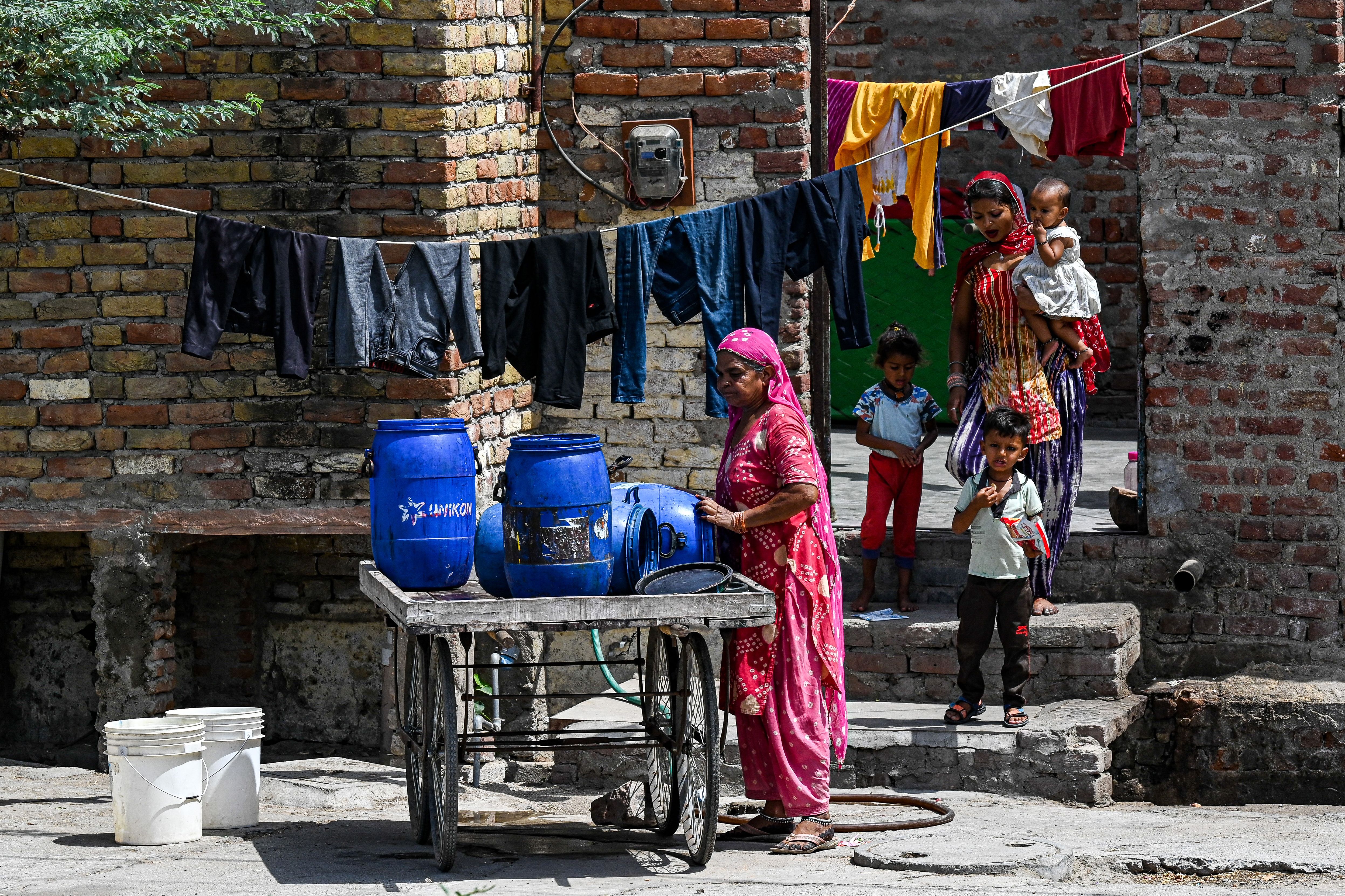 A woman preparing to fetch water from a special train on a hot summer day in Pali