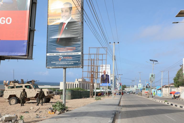 African Union (AU) peace keepers stand next to election banners of presidential candidates along a street in Mogadishu