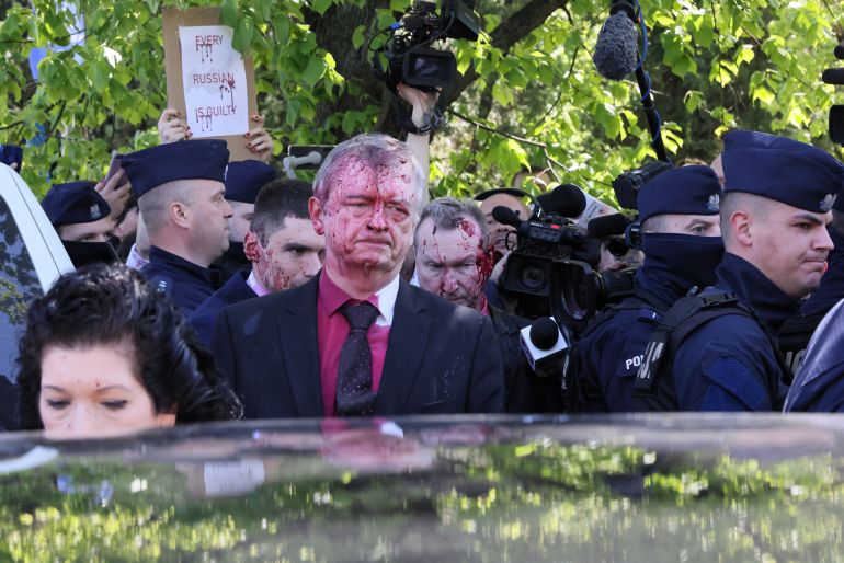 Russian ambassador to Poland, Siergiej Andriejew (C) was doused with red paint in Warsaw