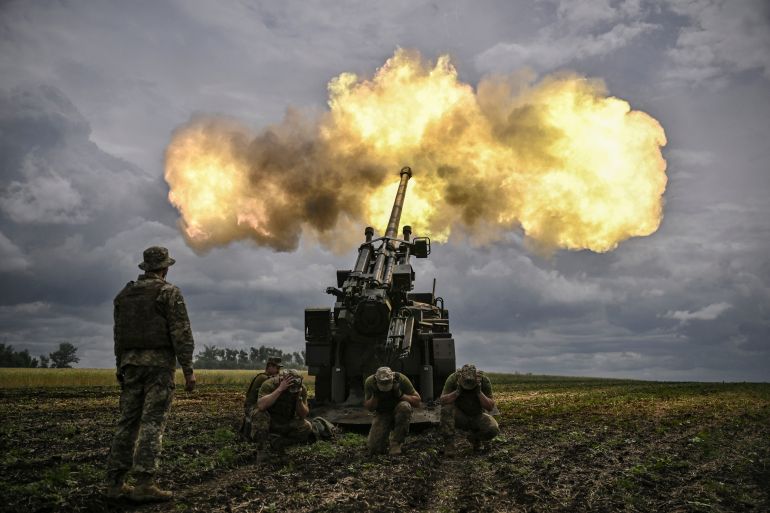 Ukrainian servicemen fire with a French self-propelled 155 mm/52-calibre gun Caesar towards Russian positions at a front line in the eastern Ukrainian region of Donbas on June 15, 2022