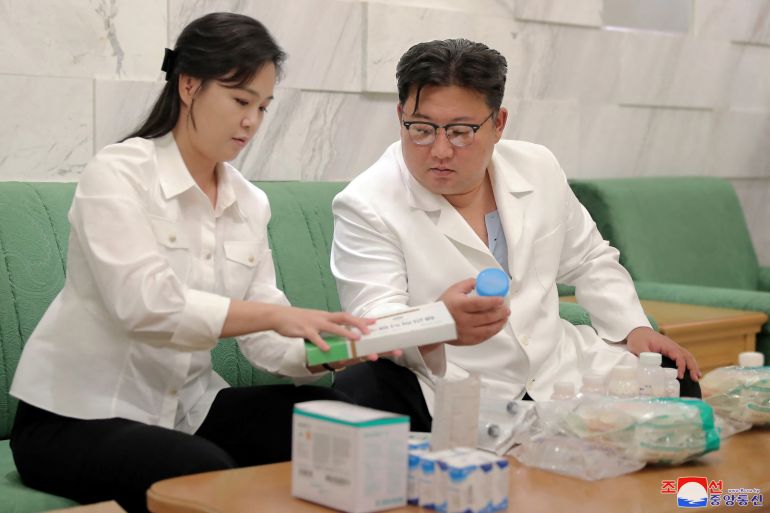 N Korean leader Kim Jong Un in a white doctor's-style coat packs medicines to send to Haeju City