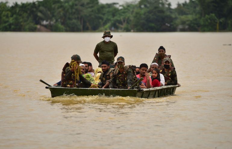 Indian army soldiers evacuate people from a flooded area in Assam’s Hojai district
