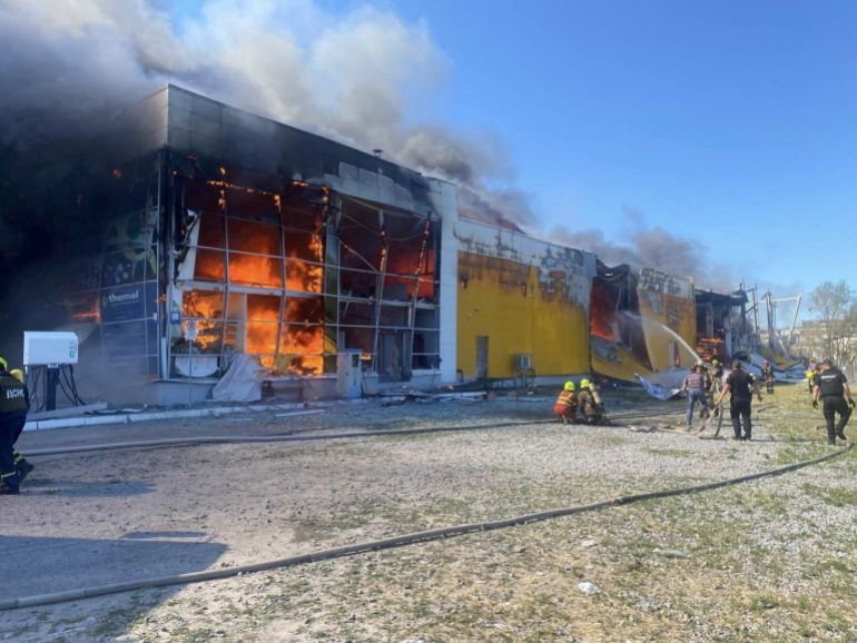 Rescuers work at a site of a shopping mall hit by a Russian missile strike, as Russia's attack on Ukraine continues, in Kremenchuk, in Poltava region, Ukraine