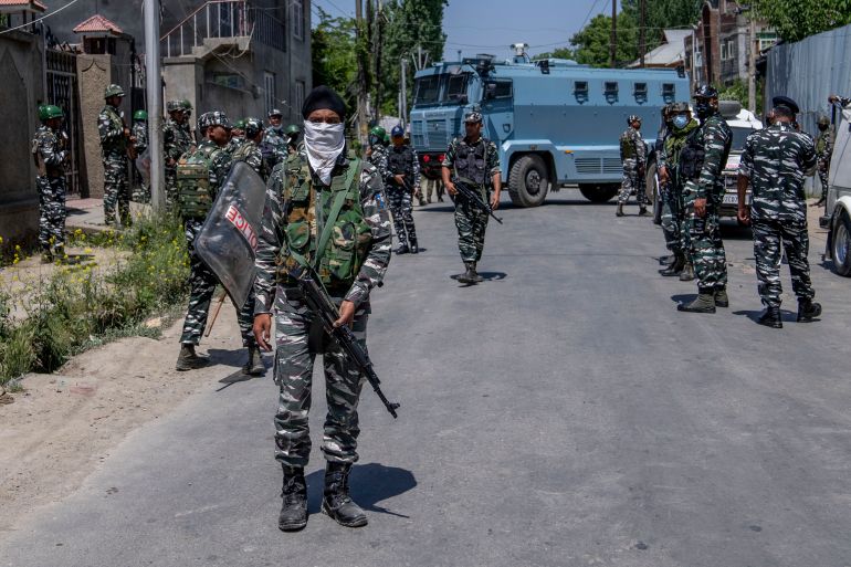 Paramilitary soldiers stand guard after dispersing Kashmiri Hindus, locally known as Pandits, during a protest march against the killing of Rahul Bhat, also a Pandit, on the outskirts of Srinagar, Indian-administered Kashmir, on Friday, May 13, 2022.